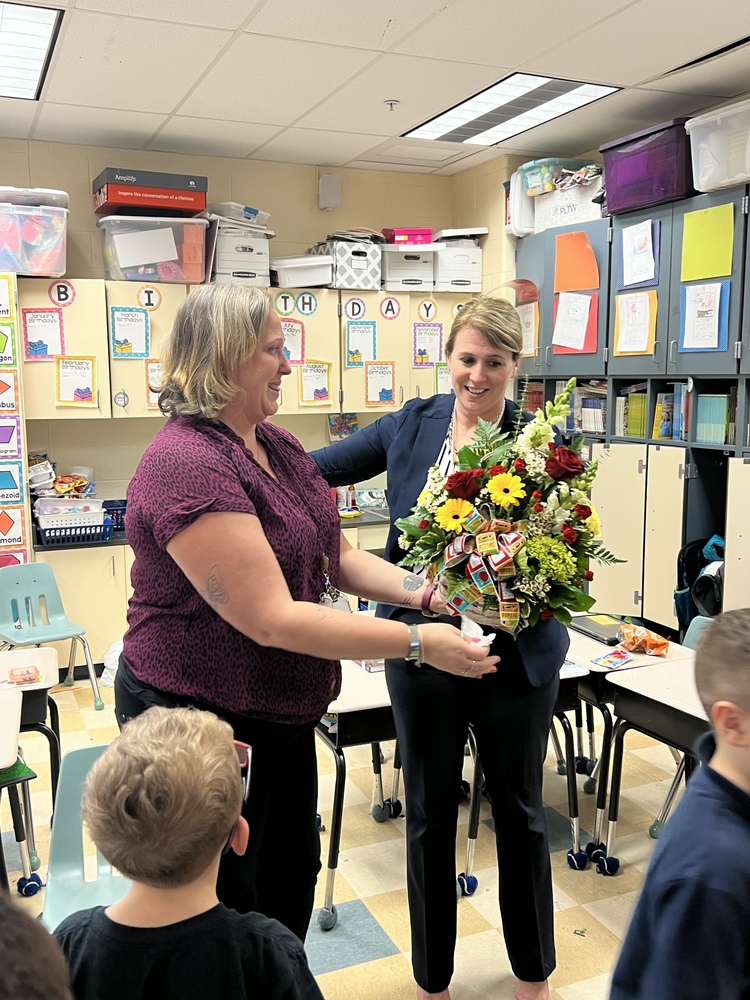 Principal presenting flower to Teacher of the Year winner