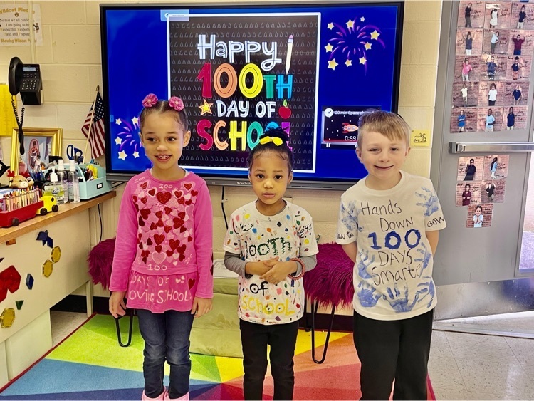 Three students standing in front of 100th day banner.