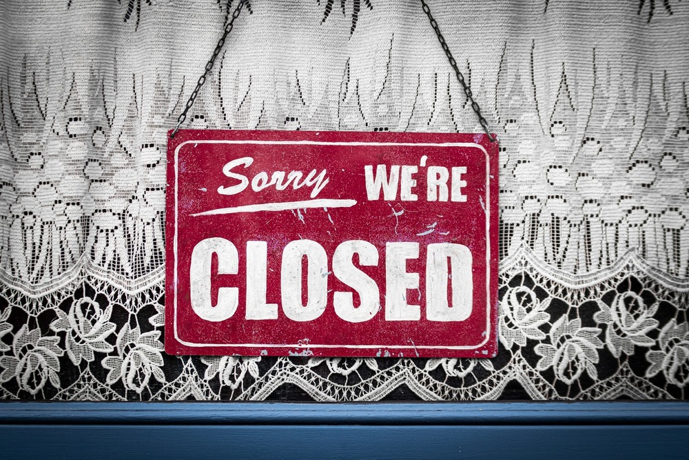 Sorry We're Closed sign hung in a window